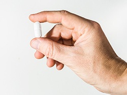 Man’s hand holding pill for oral conscious sedation